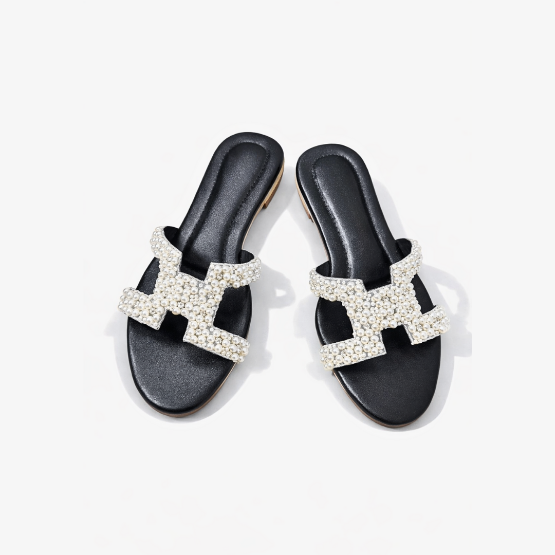 Black sandals with decorative 'H' design on a white background