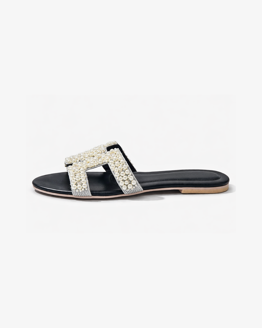 Black sandal with white embellishments on a white background