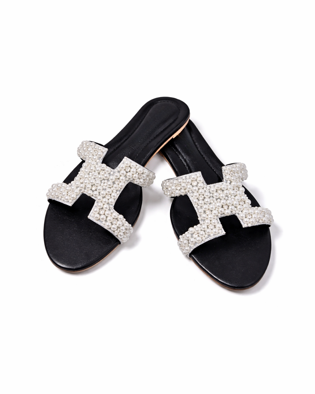 Black slides with white embellished 'H' design on a white background