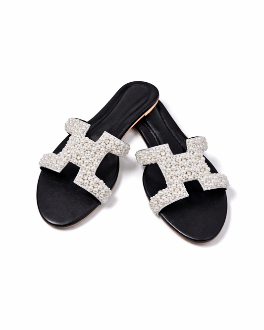 Black slides with white embellished 'H' design on a white background